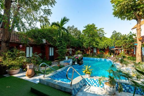 einen Pool in einem Garten mit Bäumen und einem Haus in der Unterkunft Green Peace Bungalow in Ninh Bình