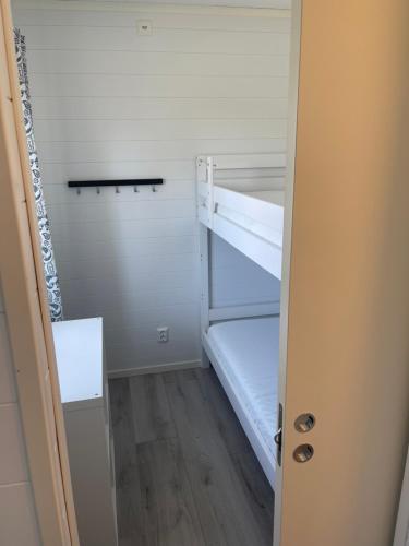 a small room with a bunk bed and a door at Kaptenhuset Skrea strand in Falkenberg