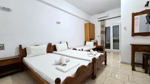 a bedroom with two beds and a fireplace at Amarandos Studios - Rooms & Apartments in Marantochori