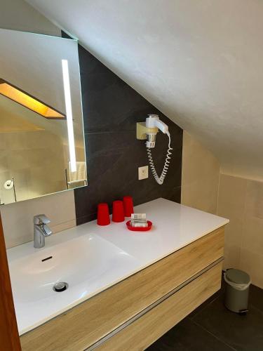 La salle de bains est pourvue d'un lavabo et d'un téléphone mural. dans l'établissement La Grange du Pape - Annexe de l'Hôtel La Ferme du Pape, à Eguisheim