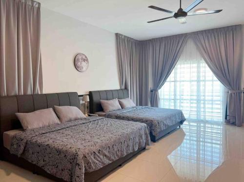 1 dormitorio con 2 camas y ventilador de techo en Sweet HOME FOR BIG Family｜11pax+FREE WIFI, en Sitiawan