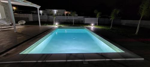 a swimming pool in a backyard at night at Janus Casa nel Verde - Relax Pool & Spa in Giano Vetusto