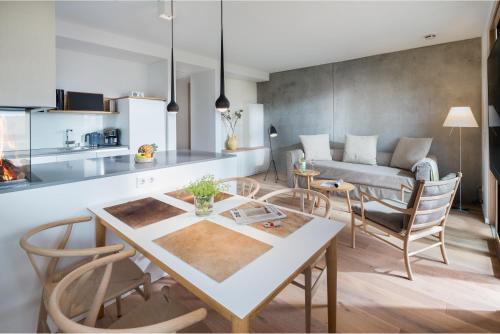 een keuken en een woonkamer met een tafel en stoelen bij Dünenblick in Norderney