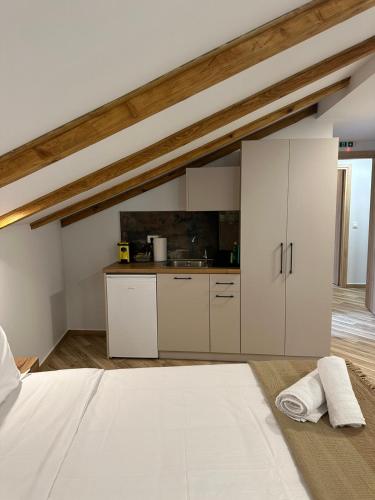 a kitchen with white cabinets and a bed in a room at Meteora Sunrise in Kalabaka