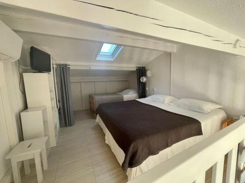 une chambre avec un lit et une télévision dans l'établissement Les Issambres, appartement face mer Golf St Tropez, aux Issambres