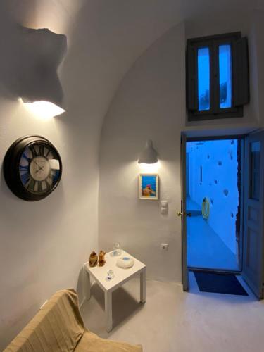 ein Wohnzimmer mit einer Uhr, einem Tisch und einer Tür in der Unterkunft Villaggio One in Emporio