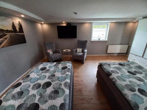 a bedroom with two beds and a flat screen tv at Ferienwohnung BeLa, Nähe Nürburgring in Luxem