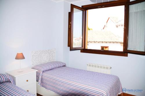 a bedroom with two beds and a window at la cotera vut in Colombres