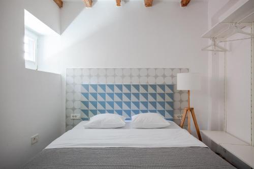 een slaapkamer met een bed met een blauw en wit hoofdeinde bij Labum accommodation in Izola