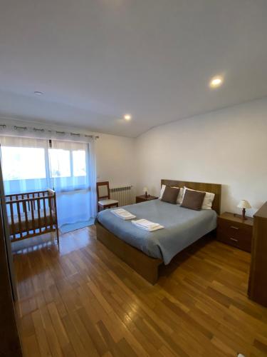 een slaapkamer met een groot bed en een raam bij Casa de Casarelhos - Casa de férias - Gerês in Geres