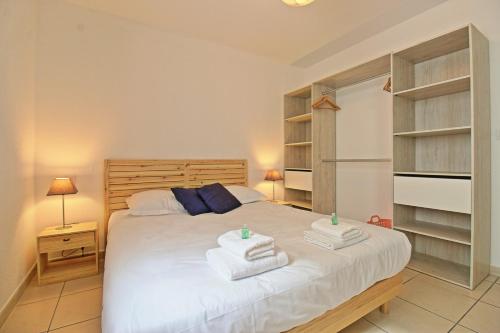 een slaapkamer met een bed met handdoeken erop bij L'Ecluse - Clim - Parking - Central in Nîmes