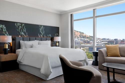 a bedroom with a large white bed and a large window at The Westin Cape Town in Cape Town