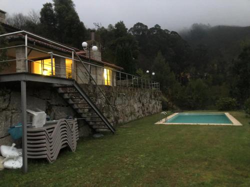 a house with a balcony and a swimming pool at Gerês - Caniçada in Caniçada