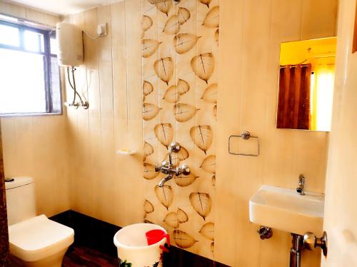 a bathroom with a toilet and a sink at Suncrest Wood Stayz in Alibaug