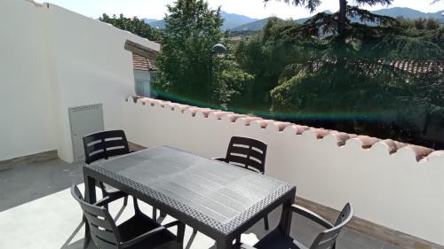 a table and chairs on a patio with a view of a mountain at The Sunrise in San Teodoro