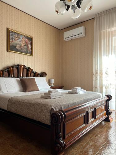 a bedroom with a large bed and a chandelier at Elios Apartment in Tropea