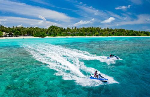 two people are water skiing in the ocean at Amilla Maldives in Kihaadhoo