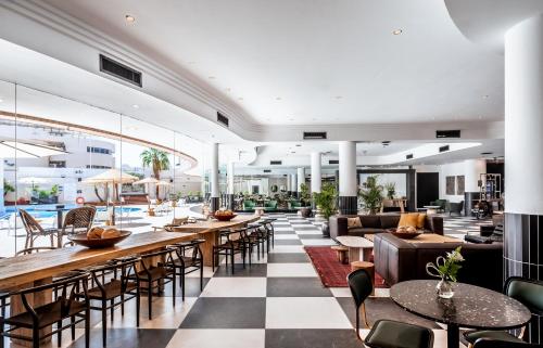 a lobby of a hotel with tables and chairs at Jacob Eilat in Eilat