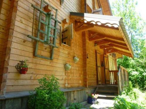 a wooden house with a door and a porch at CHALET DE BASSEY in Le Bourg-dʼOisans