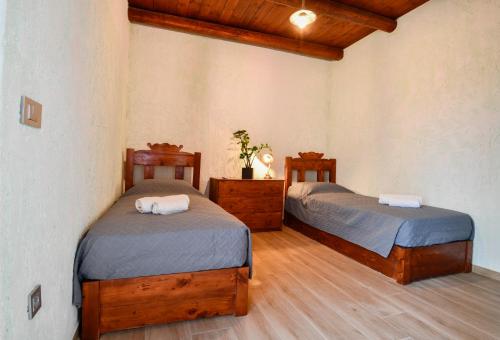 two beds in a room with wooden floors at VILLA DEMETRA in Kissamos