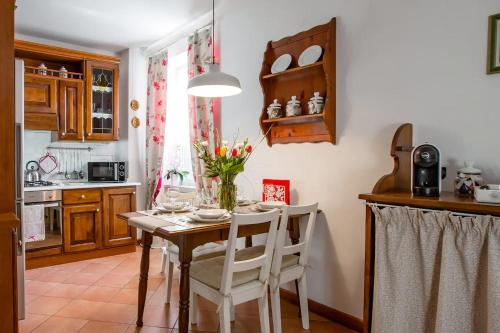 una cucina con tavolo e vaso di fiori di TRENTINO LODGE Via San Vito a Strigno
