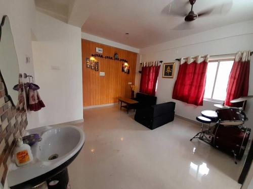 a bathroom with a sink and a living room with a couch at Debjit Residency for Family only in Kolkata