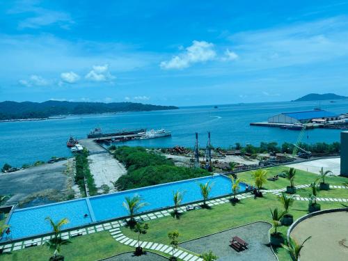 a view of a large swimming pool next to a body of water at JQ1 SEA & POOL or CITY View WIFI I WASHING MACHINE for Some Units I CUCKOO WATER Jesselton Quay by R2 in Kota Kinabalu