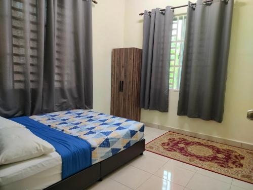 a bedroom with a bed and a window with curtains at Family Homestay Taman Vistana Indah Alor Setar in Langgar