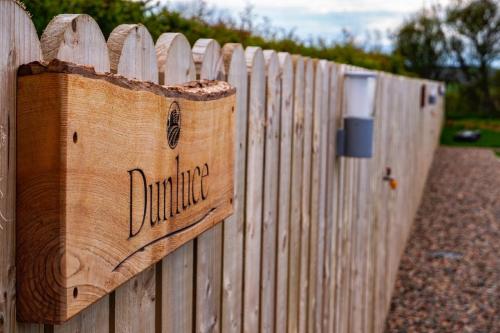 a wooden fence with a sign on it at Causeway Country Pods in Bushmills