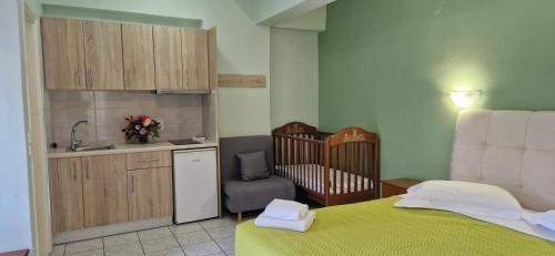 a bedroom with a crib and a kitchen with a sink at Christina Studios in Lygia