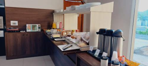a kitchen with a counter with food on it at Prime Hotel Hortolândia in Hortolândia