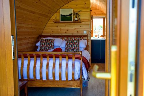 um quarto com uma cama num chalé de madeira em Causeway Country Pods em Bushmills