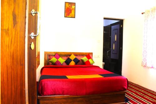a bedroom with a bed with a red blanket at Arabian Nights Munnar Pool Villa in Munnar