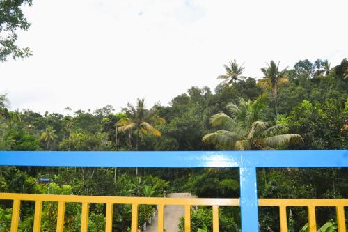 a blue and yellow bench with trees in the background at Arabian Nights Munnar Pool Villa in Munnar