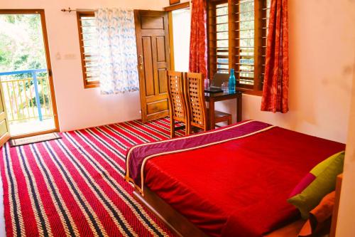 a bedroom with a red bed and a window at Arabian Nights Munnar Pool Villa in Munnar