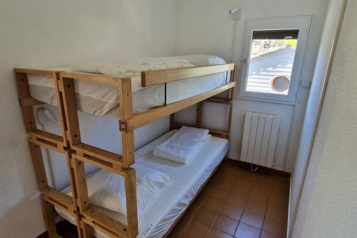a small room with two bunk beds and a window at Ô Soleil - T3 à 50m de la plage des Lecques in Saint-Cyr-sur-Mer