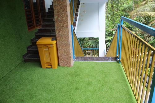a stairway with a yellow trash can on the grass at Arabian Nights Munnar Pool Villa in Munnar