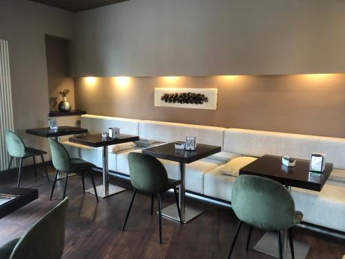 a restaurant with four tables and a couch at HOTEL DEL CORSO in Borgomanero