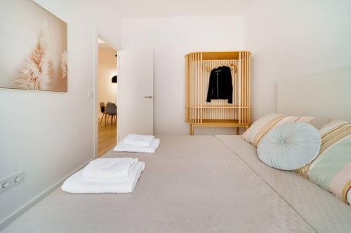ein weißes Zimmer mit zwei weißen Handtüchern auf dem Boden in der Unterkunft Esplendido apartamento en el centro in Málaga