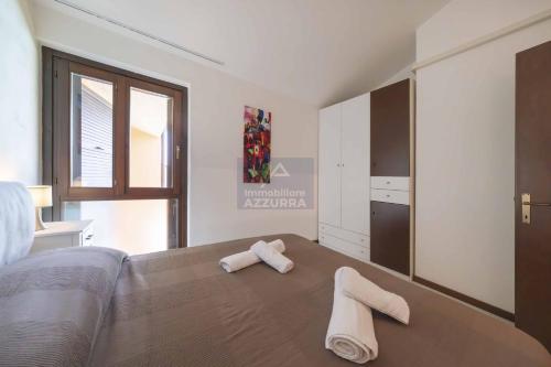una camera da letto con un letto e due asciugamani di La Palma - Immobiliare Azzurra a Lazise