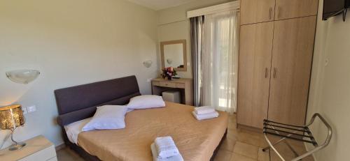 a small bedroom with a bed with towels on it at Christina Studios in Lygia