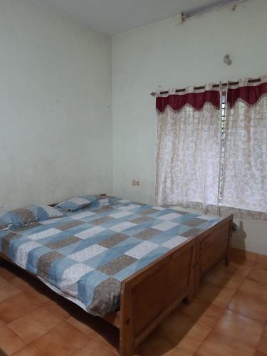 a bedroom with a large bed in a room with curtains at Nandanam homestay in Varkala