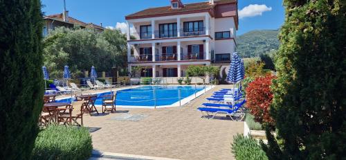 a resort with a pool and chairs and a building at Christina Studios in Lygia