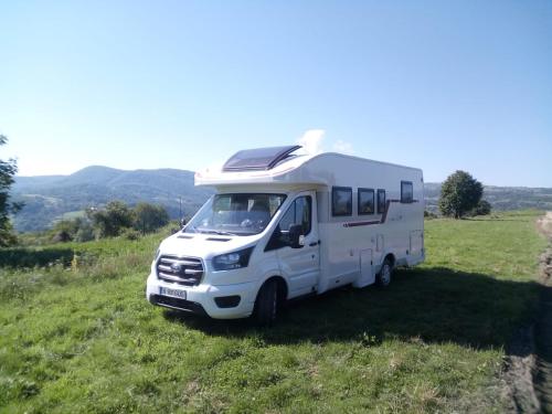 a white camper van parked in a field at SONIA in Otopeni
