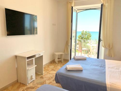 a bedroom with a bed and a view of the ocean at Hotel Marconi in Sperlonga