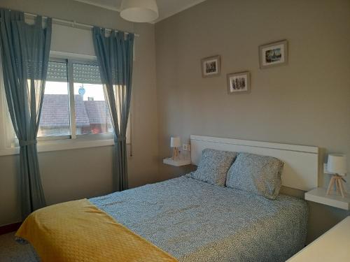 um quarto com uma cama e uma janela em Apartamento vacacional en Playa del Vao - Corujo em Vigo