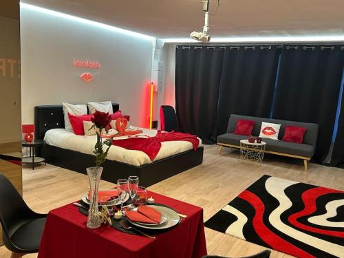 a living room with a bed and a table with a table sidx sidx at Love Room 80m2 BDSM 50 nuances de Grey - SAUNA - Parking gratuit in Antibes