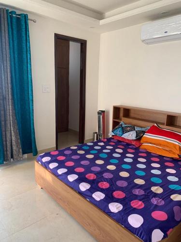 1 dormitorio con 1 cama con un edredón colorido en Nature's Blessing Rishikesh 1BHK Studio, en Rishīkesh