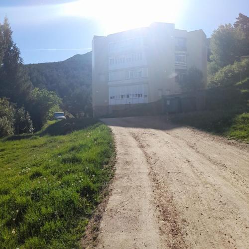 a dirt road in front of a large building at Albergue La Pinilla in Madrid