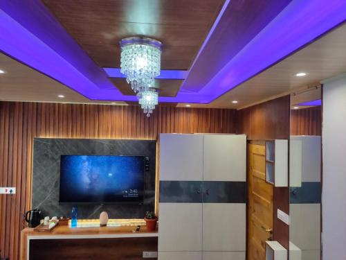 Cette chambre dispose d'une télévision et d'un plafond violet. dans l'établissement Shimla Abode, à Shimla